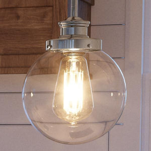 A beautiful Polished Nickel Finish pendant lamp from the Glasgow Collection with a glass globe hanging from it.