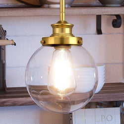 An UHP2641 Vintage Pendant lighting fixture with a glass globe hanging from it.