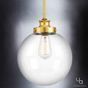 The Urban Ambiance UHP2643 Vintage Pendant from the Glasgow Collection showcases a native brass finish and a clear glass globe shade with an exposed filament bulb, elegantly displayed against a gray background. Measuring 12-3/4″ high by 9-3/4″ wide, this modern lighting piece adds vintage charm to any space.