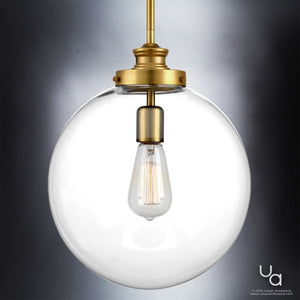 The UHP2645 Vintage Pendant from Urban Ambiance’s Glasgow Collection features a round glass globe with a clear shade, exposed filament bulb, and native brass finish. Measuring 15″ high by 12″ wide, this modern lighting fixture brings sophisticated style to any space and is showcased here against a gray gradient background.