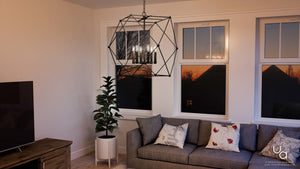 A living room with a unique Urban Ambiance UHP2702 Contemporary Chandelier and a gray couch.