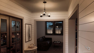 A narrow hallway with white shiplap walls leads to a small sitting area featuring a dark sofa, a window, and the Urban Ambiance UHP2705 Contemporary Ceiling Fixture from the Aberdeen Collection in midnight black, suspended overhead.