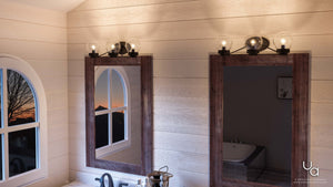 An Urban Ambiance bathroom with two unique UHP2707 Contemporary Bathroom Vanity Lights, Midnight Black Finish, Aberdeen Collection sinks and a mirror.