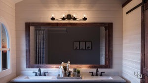 A beautiful and unique Urban Ambiance bathroom with two sinks and a mirror, featuring the UHP2708 Contemporary Bathroom Vanity Light from the Aberdeen Collection, in Midnight Black Finish.
