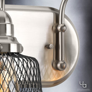 Close-up of the Urban Ambiance UHP2720 Vintage Bathroom Vanity Light from the Eugene Collection, showcasing a brushed nickel wall sconce with a wire cage cover and an exposed bulb, measuring 8.375″ high by 15″ wide, mounted on a light-colored wall.