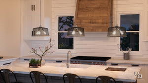 Modern kitchen with marble island, wood range hood, stove, sink, decorative plants, and two windows above the counter; features a UHP2728 Vintage Chandelier in brushed nickel from Urban Ambiance’s Eugene Collection (10.25″H x 16″W) as an industrial pendant light.