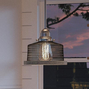 A gorgeous luxury lamp hangs over a window in a kitchen.