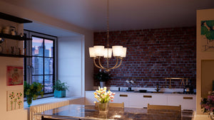 A kitchen with a table and chairs, featuring the gorgeous Urban Ambiance UHP2765 Transitional Chandelier from the Boise Collection.