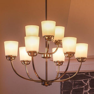 A beautiful Urban Ambiance UHP2767 Transitional Chandelier with white shades hanging over a fireplace.
