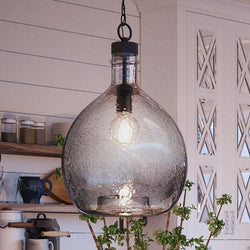 A large luxury lighting fixture, the Urban Ambiance UHP2770 Modern Farmhouse Pendant, hangs over a kitchen counter.