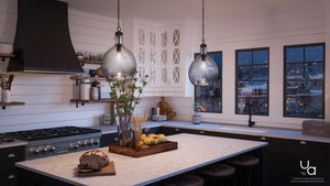 A modern kitchen features a marble island and the UHP2770 Modern Farmhouse Pendant from Urban Ambiance’s Hobart Collection (20-3/8″H x 13″W, Charcoal Finish) illuminating the space. A loaf of bread sits on a cutting board, while large textured glass windows offer a view of the city at dusk. Kitchenware and decor are neatly arranged throughout the room.