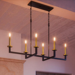 The Urban Ambiance UHP2803 Modern Farmhouse Chandelier from the Cordoba Collection features a rectangular design in a charcoal finish, with six candle-style lights suspended by two black chains from the ceiling, illuminating the warmly lit room.