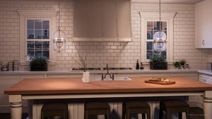 A rendering of a kitchen with white cabinets and wooden countertops featuring the unique UHP2840 Vintage Chandelier from the Varna Collection, by Urban Ambiance.