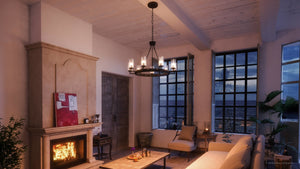 A cozy living room at dusk features a lit fireplace, beige furniture, sea view, and the Urban Ambiance UHP2892 XL Rustic Chandelier (24-7/8