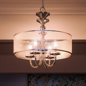 A unique luxury lighting fixture, the Urban Ambiance UHP2922 Cosmopolitan Chandelier in a polished nickel finish hangs in a dining room.