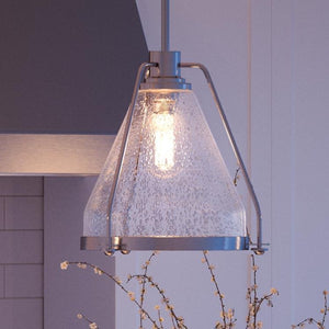 A beautiful pendant light from the Rochdale Collection, specifically the UHP2990 Industrial Pendant Light with a glass shade, is hanging over a fireplace.