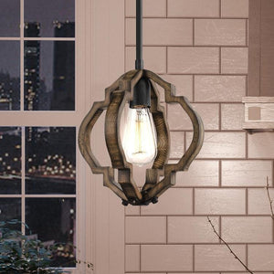 The UHP3032 Rustic Pendant Light from the Wycombe Collection by Urban Ambiance features an 11″ x 10″ wooden geometric frame with an exposed bulb and an Olde Iron finish, elegantly hanging indoors near a window overlooking the cityscape.