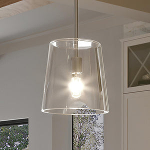 A kitchen with a unique lighting fixture, the UHP3090 Colonial Pendant Light from the Tustin Collection by Urban Ambiance, hanging over a window.