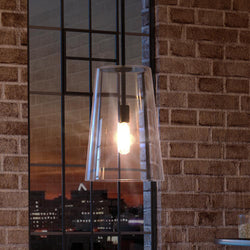 A luxurious Colonial pendant lamp with a beautiful midnight black finish, placed in a room with a brick wall.