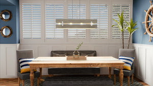 A unique and beautiful dining room with blue walls and shutters illuminated by the UHP3360 Modern Farmhouse Chandelier from the Southfield Collection by Urban Ambiance.