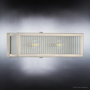 A Stainless Steel Finish Vanity Light from the Bismarck Collection with two glass panels on a dark background, adding a touch of luxury to any urban ambiance.