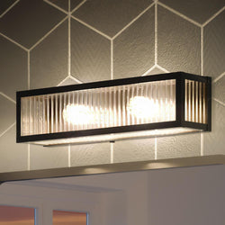 A beautiful Urban Ambiance UHP3581 Minimalist Bath Vanity Light with a geometric pattern on the wall from the Bismarck Collection.