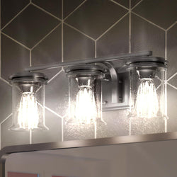 Three gorgeous UHP3760 French Country Bath Vanity Lights, luxury lighting fixtures from the Missoula Collection by Urban Ambiance in a bathroom with tiled walls.