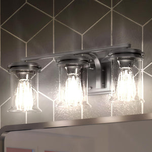 Three gorgeous UHP3760 French Country Bath Vanity Lights, luxury lighting fixtures from the Missoula Collection by Urban Ambiance in a bathroom with tiled walls.