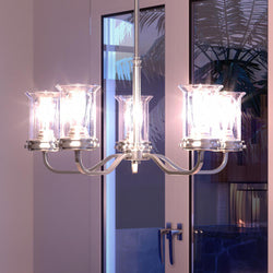 A gorgeous French Country chandelier from the Missoula Collection by Urban Ambiance in a room with a glass door.