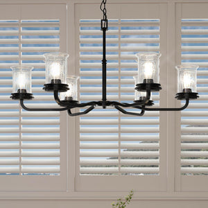 A unique lighting fixture, a French country chandelier with a midnight black finish, hanging over a table with shutters.