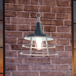 A beautiful UHP3852 Urban Ambiance pendant light, with a unique gray blue finish from the Frederick Collection, hanging from a brick wall.