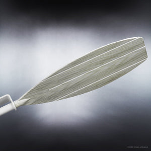 A close-up of a single matte white blade with a subtly textured surface, photographed against a dark background with a dramatic spotlight effect, evokes the sleek, modern design of the Urban Ambiance UHP9012 Urban Loft Indoor or Outdoor Ceiling Fan from the Mendocino Collection.