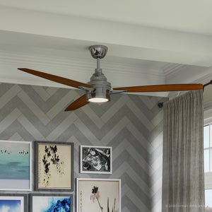 The Urban Ambiance UHP9041 Mid Century Modern Indoor Ceiling Fan from the Tybee Collection, featuring three wooden blades and a built-in light fixture in a brushed nickel finish (13.1″H x 60″W), is mounted on a white ceiling above a wall with herringbone tile and framed artwork.