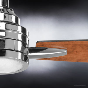 Close-up of the Urban Ambiance UHP9043 Mid Century Modern Indoor Ceiling Fan from the Tybee Collection, showcasing a polished chrome central fixture and a wooden fan blade, set against a gradient background.