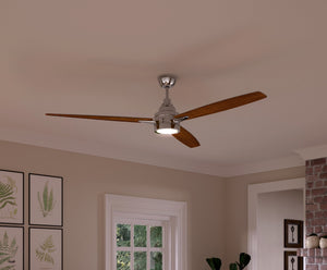 The Urban Ambiance UHP9043 Mid Century Modern Indoor Ceiling Fan from the Tybee Collection, featuring three wooden blades and a central light fixture in polished chrome (13.1″H x 60″W), is mounted on a white ceiling in a room adorned with framed art, a window, and part of an exposed brick wall.