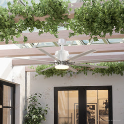 An UHP9052 Urban Loft Indoor / Outdoor Ceiling Fan, 16.8"H x 72"W, White, Chatham Collection by Urban Ambiance in a patio with plants.