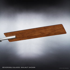 A single ceiling fan blade in a walnut finish, compatible with the UHP9061 Urban Loft Indoor Ceiling Fan from the Amelia Collection by Urban Ambiance, is displayed against a gradient grey background. Text at the bottom highlights that this reversible blade is an ideal replacement for industrial or farmhouse-style ceiling fans featuring reversible blades.