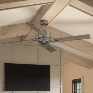 An Urban Ambiance UHP9061 Urban Loft Indoor Ceiling Fan from the Amelia Collection, featuring four reversible wooden blades and an aged nickel finish, is mounted on a high ceiling with exposed beams. A flat-screen TV is mounted on the wall below.