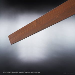 A single American walnut reversible blade from the Urban Ambiance Camden Collection is displayed against a gray gradient background, illustrating the sleek architectural appeal of the UHP9070 Modern Indoor Ceiling Fan (9.9″H x 56″W, Brushed Nickel).