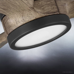 Close-up of the Urban Ambiance UHP9090 Modern Indoor Ceiling Fan from the Lewes Collection, featuring a charcoal finish and measuring 15.5 inches high by 60 inches wide, casting a gentle white glow onto a gray surface.