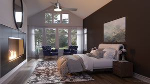 Modern bedroom with a fireplace, large windows, and vaulted ceiling. The room features a bed, two blue chairs, and a rug with views of nature outside. Completing the space is the Urban Ambiance UHP9210 Modern Indoor Ceiling Fan from the Capitola Collection (15.8″H x 52″W, Brushed Nickel), which enhances both comfort and style.