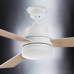 Close-up of the Urban Ambiance UHP9212 Modern Indoor Ceiling Fan from the Capitola Collection, featuring a white base and three light wood blades, measuring 15.8″ high by 52″ wide, set against a gradient gray background.