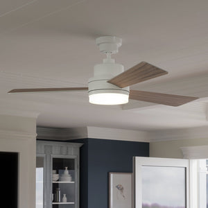 The Urban Ambiance UHP9212 Modern Indoor Ceiling Fan from the Capitola Collection, featuring three wooden blades and an integrated energy-saving LED light fixture, is mounted on a white ceiling in a stylish home interior.