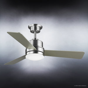 The Urban Ambiance UHP9221 Modern Indoor Ceiling Fan from the Capitola Collection features three metallic blades and a central light fixture, all in a brushed nickel finish. Measuring 15.6 inches high by 44 inches wide, this ceiling fan is mounted on a short downrod and displayed against a gradient gray background, seamlessly combining modern elegance with functionality.