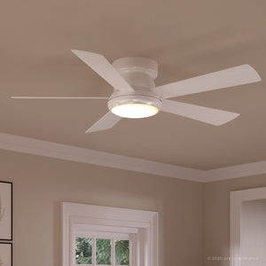 The Urban Ambiance UHP9232 Traditional Indoor Ceiling Fan from the Beaufort Collection features five blades and an integrated LED light with an opal glass diffuser. It is installed on a beige ceiling in a room accented with crown molding and framed wall art. The fan measures 11.6 inches in height and 52 inches in width, finished in white.