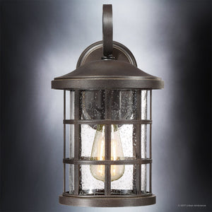 Add timeless elegance to your exterior with the Urban Ambiance UQL1043 Craftsman Outdoor Wall Light from the Vienna Collection. Featuring a Parisian Bronze finish, a clear glass shade, and marine-grade construction, this 14.25″H x 8″W wall sconce showcases a visible bulb and gracefully curved arm. Its refined design brings classic charm to your entryway while delivering lasting durability.