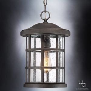 The Urban Ambiance UQL1049 Craftsman Outdoor Pendant Light from the Vienna Collection features a marine-grade metal frame in a Parisian Bronze finish with clear seeded glass panels, showcasing a visible light bulb inside for classic charm. Measures 15.5″ high by 10″ wide.