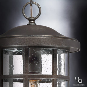 Close-up of the Urban Ambiance UQL1049 Craftsman Outdoor Pendant Light from the Vienna Collection, featuring a Parisian Bronze finish and clear seeded glass panels with water droplet patterns, highlighting its 15.5″H x 10″W marine-grade construction and charming pendant effect.