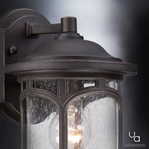 Close-up of the Urban Ambiance UQL1101 Rustic Outdoor Wall Light from the Sydney Collection, showcasing its weather-resistant marine-grade construction, Parisian Bronze finish, and clear textured glass with a lit bulb inside.