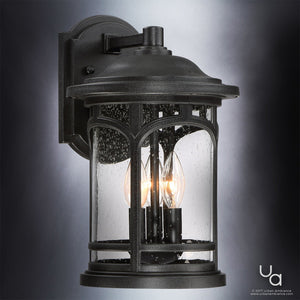 The Urban Ambiance UQL1102 Rustic Outdoor Wall Light from the Sydney Collection features a black silk finish, marine-grade construction, clear seeded glass, two candle-style bulbs, and an arched top with decorative metal frame. Measures 14.5